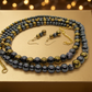 Jewelry on a gold Christmas gift box with festive flowers and soft spotlight