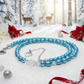 Light-blue necklace lying on sparkling snow in a Christmas forest