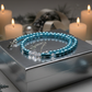 Light-blue necklace on a silver gift box with Christmas décor